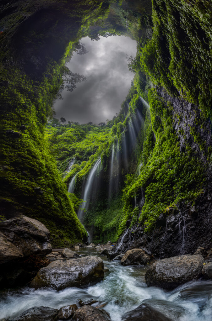 cave with green moss, sky, water