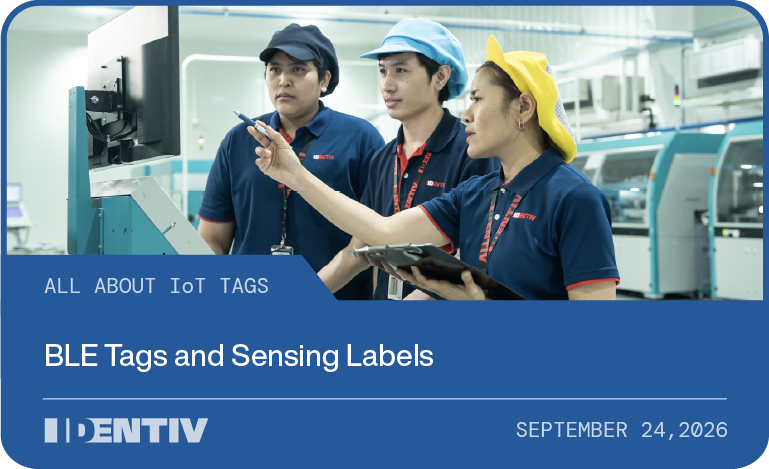 Three Identiv team members reviewing a monitor on the production floor, cover image for the All About IoT Tags guide to BLE tags and sensing labels